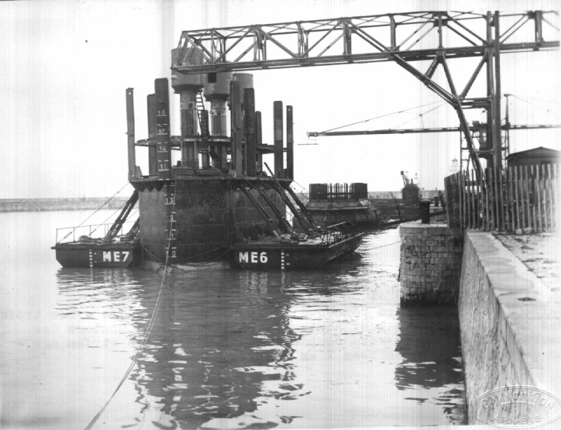 Caisson P.6, prêt a être remorqué,
 les flotteurs sont accrochés,
 les hausses amovibles sont en partie en place,
 le complément devant être monté
 après l'échouage et le fonçage,
 les sas sont à leur hauteur définitive.