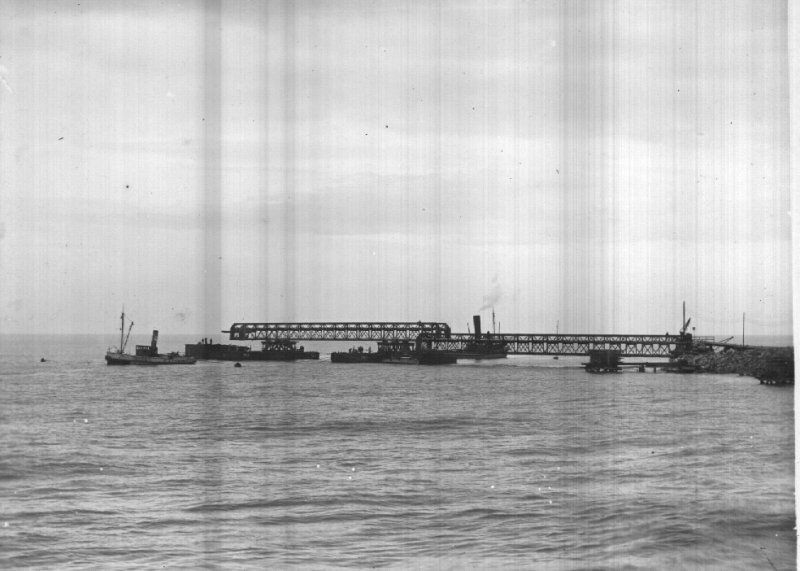 Mise en place d'une passerelle de 67 m
 reliant les caissons P.0 et P.1.
 A marée basse, la passerelle qui est sur les chalands 
 viendra poser sur les caissons P.0 et P.1.