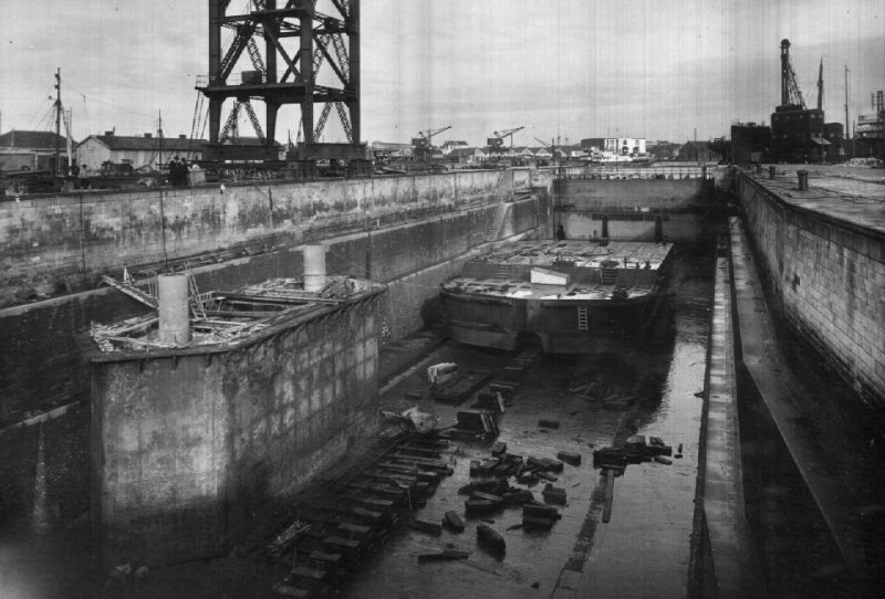 Caisson P.18, démontage du cadre inférieur
 des hausses amovibles.
Au fond de la cale de radoub, chaland porte-blocs M.E-8.