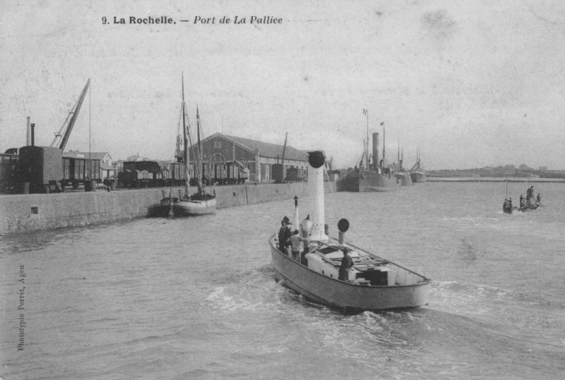  un remorqueur entre dans le bassin du port de la pallice, derriere un sous-marin